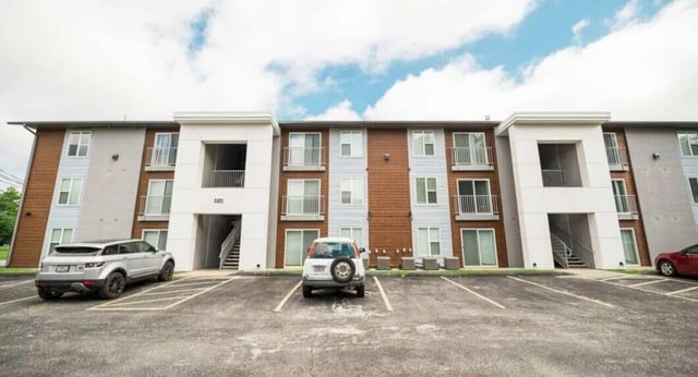 Apartment building with cars parked outside exterior at MadisonVue Apartments in Springfield Student Accommodation