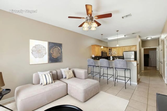 Living room with sectional sofa kitchen and bar stools living room at Stadium Properties Apartments in Tallahassee Student Accommodation