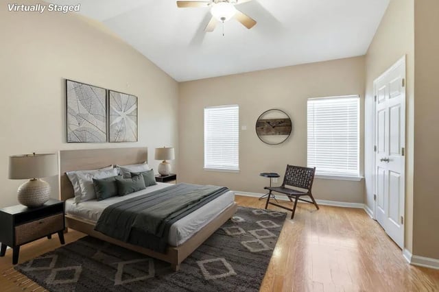 Bed with nightstands chair artwork ceiling fan bedroom at Stadium Properties Apartments in Tallahassee Student Accommodation