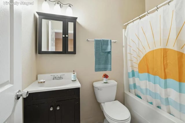 Sink toilet medicine cabinet sun shower curtain bathroom at Stadium Properties Apartments in Tallahassee Student Accommodation