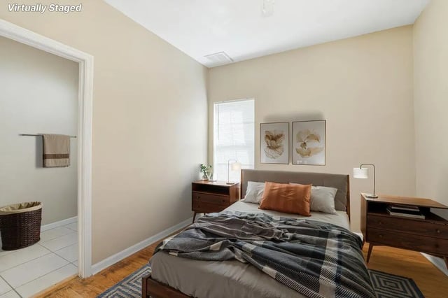 Bed side table framed art and plaid blanket bedroom at Stadium Properties Apartments in Tallahassee Student Accommodation