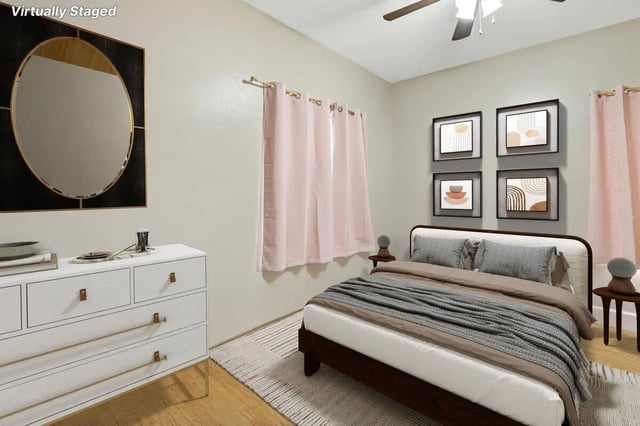 White dresser oval mirror bed with pink curtains bedroom at Stadium Properties Apartments in Tallahassee Student Accommodation