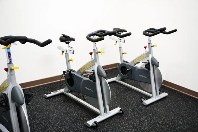 Exercise bikes on black textured floor gym area at Highland Quarters in Terre Haute Student Accommodation