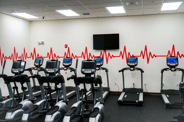 Gym with treadmills and elliptical machines fitness room at Highland Quarters in Terre Haute Student Accommodation