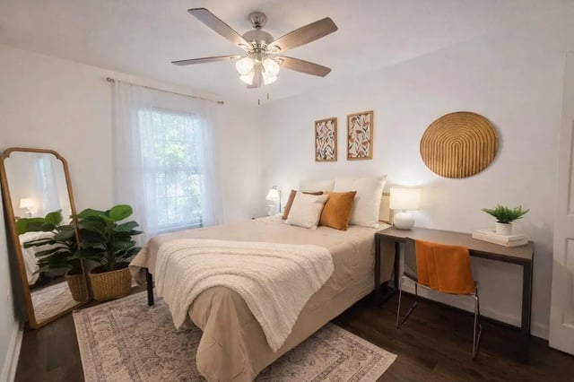 Bed with pillows desk chair and plants bedroom at Villa Cristina in Tallahassee Student Accommodation