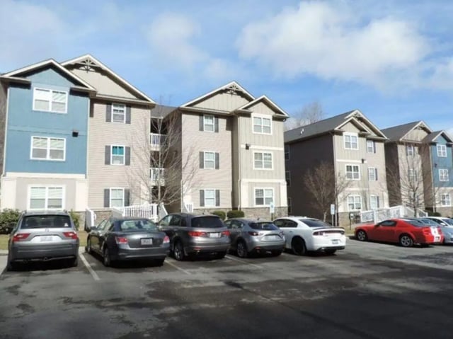 Apartment buildings with cars parked outside Exterior at Highland Woods Apartments of Boone in Boone Student Accommodation