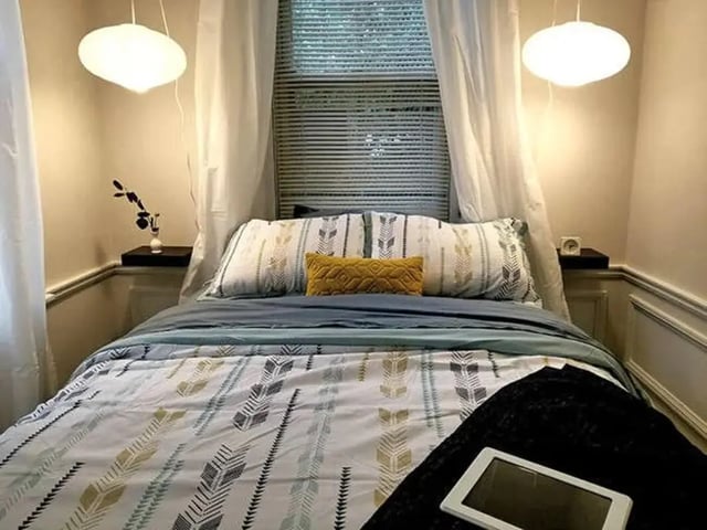 Bed with patterned duvet white pillows and tablet Bedroom at The Legacy at Drexel Arms Apartments in Philadelphia Student Accommodation