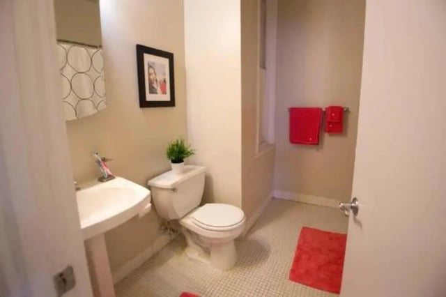 Sink toilet red towels framed picture bathroom at The Legacy at Drexel Arms Apartments in Philadelphia Student Accommodation