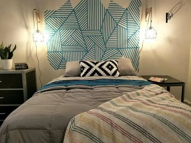 Bed with patterned wall and nightstand Bedroom at The Legacy at Drexel Arms Apartments in Philadelphia Student Accommodation