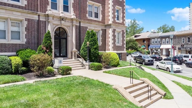 Brick building entrance with manicured shrubs exterior at The Legacy at Drexel Arms Apartments in Philadelphia Student Accommodation