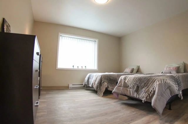 Two beds with patterned blankets and pillows bedroom at Sutton Court in State College Student Accommodation