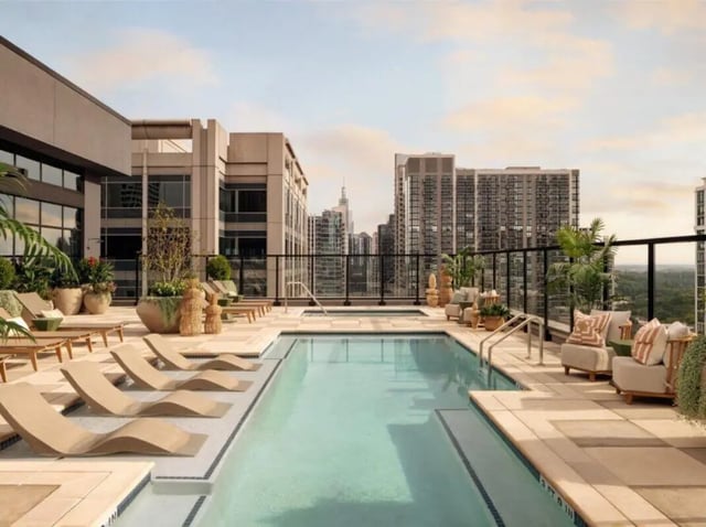 Rooftop pool with lounge chairs and city skyline playing area at Rambler Atlanta Apartments in Atlanta Student Accommodation