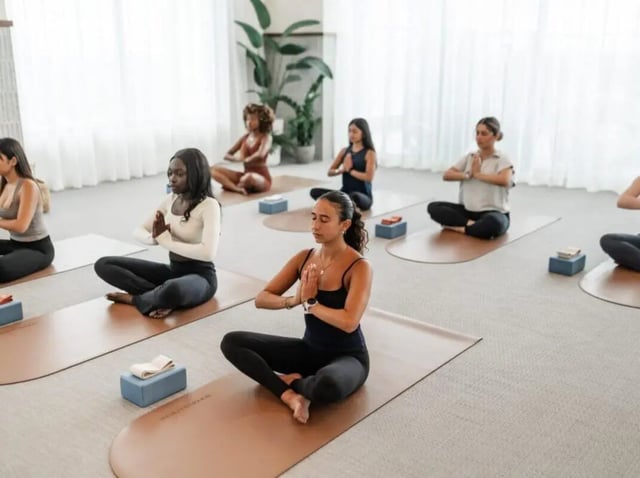 Yoga class with women meditating on mats playing area at Rambler Atlanta Apartments in Atlanta Student Accommodation