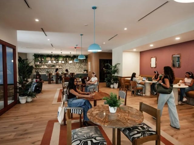 Students working at tables with laptops communal living room at Rambler Atlanta Apartments in Atlanta Student Accommodation