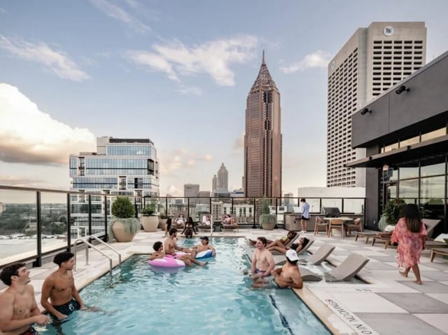 People relaxing by rooftop pool and city skyline Exterior at Rambler Atlanta Apartments in Atlanta Student Accommodation