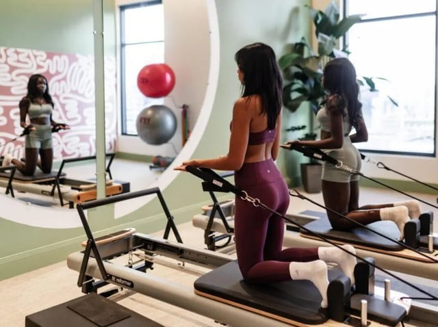 Pilates reformers with women exercising fitness room at Rambler Atlanta Apartments in Atlanta Student Accommodation