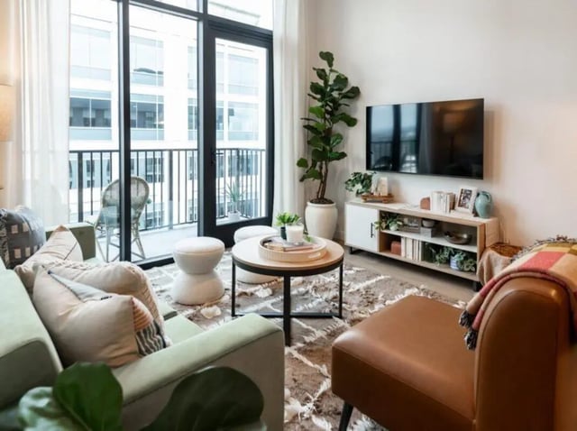 Sofa TV stand plants coffee table rug living room at Rambler Atlanta Apartments in Atlanta Student Accommodation