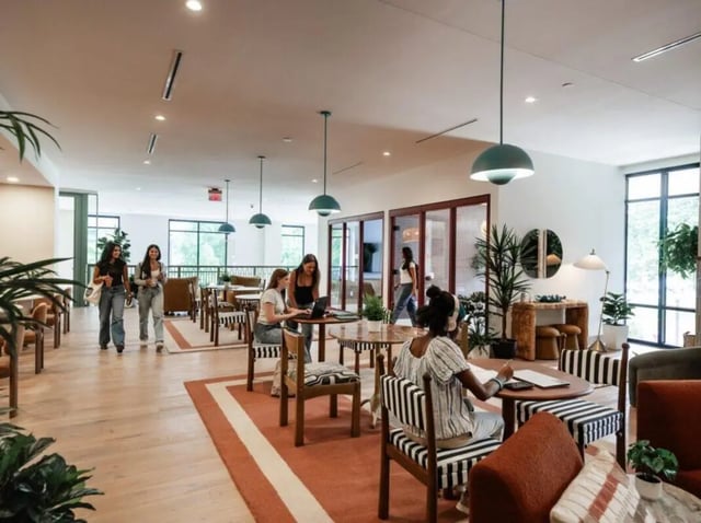 Students working and walking in common area living room at Rambler Atlanta Apartments in Atlanta Student Accommodation