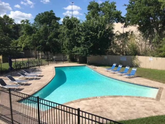 Pool with lounge chairs and trees exterior at University Terrace Apartments in State College Student Accommodation