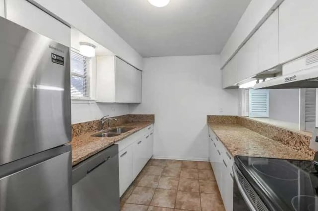 Stainless steel refrigerator granite countertops tiled floor kitchen at University Terrace Apartments in State College Student Accommodation