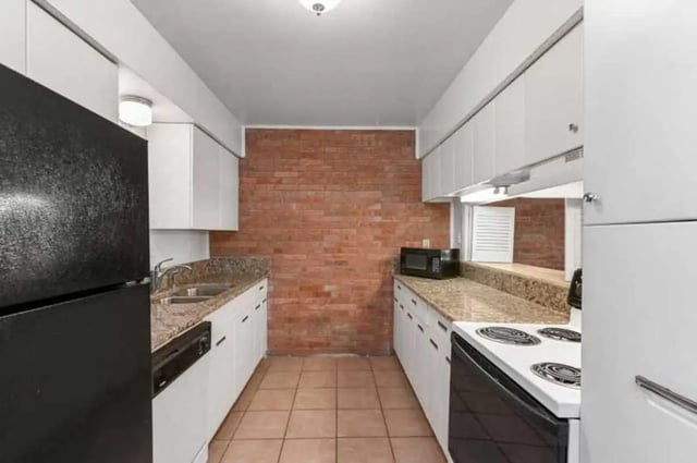 Black fridge white cabinets microwave oven kitchen at University Terrace Apartments in State College Student Accommodation