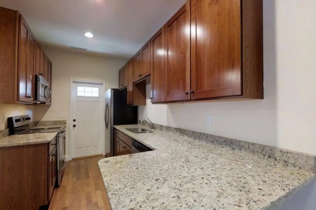 Wood cabinets microwave oven refrigerator granite counters kitchen at Forrest Edge Townhomes in Boone Student Accommodation
