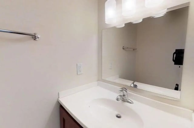 White sink vanity with mirror and lights bathroom at Forrest Edge Townhomes in Boone Student Accommodation