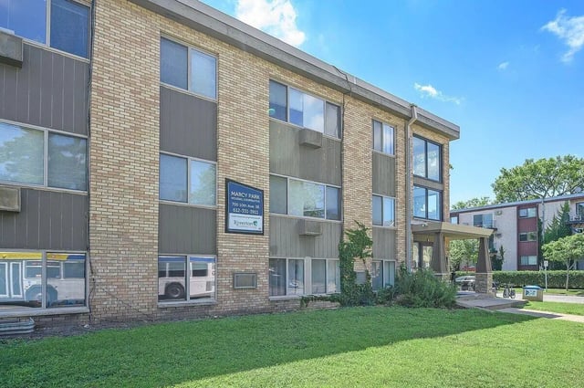 Brick building with multiple windows and grass exterior at Marcy Park Student Housing Co-op in Minneapolis Student Accommodation
