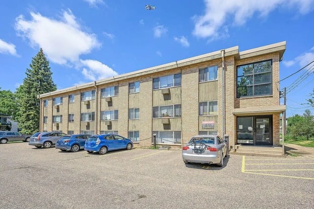Apartment building with cars and parking lot exterior at Marcy Park Student Housing Co-op in Minneapolis Student Accommodation