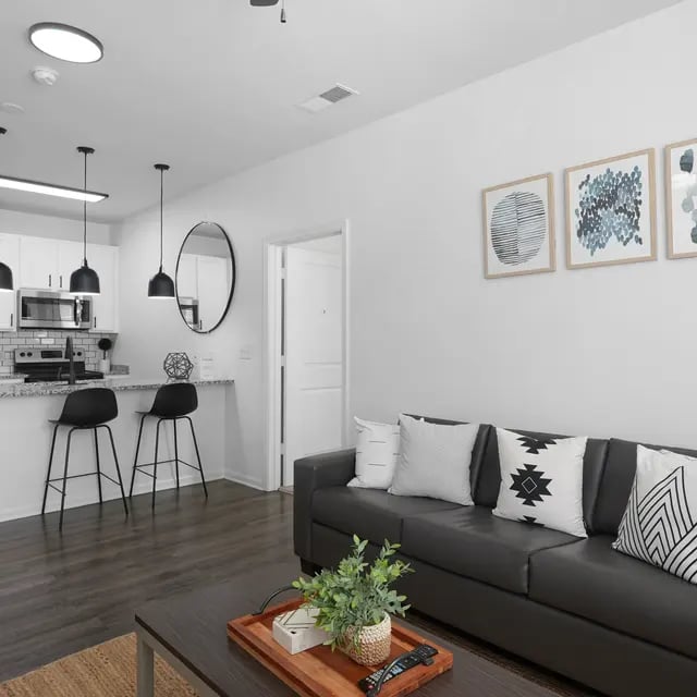 Sofa coffee table kitchen island bar stools living room at Millennium One Apartments in Charlotte Student Accommodation