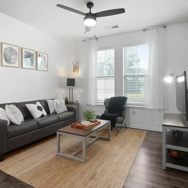 Sofa coffee table chair with blanket living room at Millennium One Apartments in Charlotte Student Accommodation