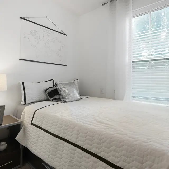 Quilted bed with decorative pillows and map bedroom at Millennium One Apartments in Charlotte Student Accommodation