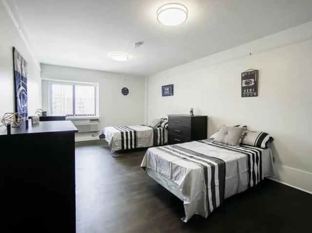 Two beds and dressers in a room. Bedroom at Greenwich Court Apartments in State College Student Accommodation