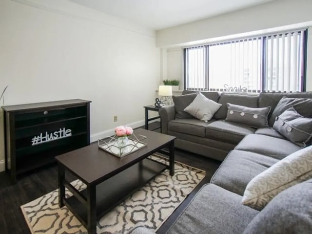 Dark sectional sofa coffee table bookshelf living room at Greenwich Court Apartments in State College Student Accommodation