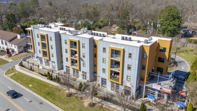 Modern apartment building with balconies and storefronts exterior at Plaza One 89 in Clemson Student Accommodation
