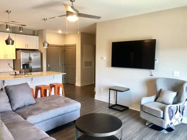 Gray sectional sofa and chair living room at Plaza One 89 in Clemson Student Accommodation