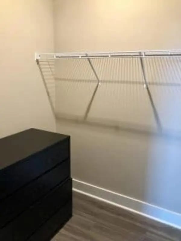 Black dresser and wire shelving closet at Plaza One 89 in Clemson Student Accommodation