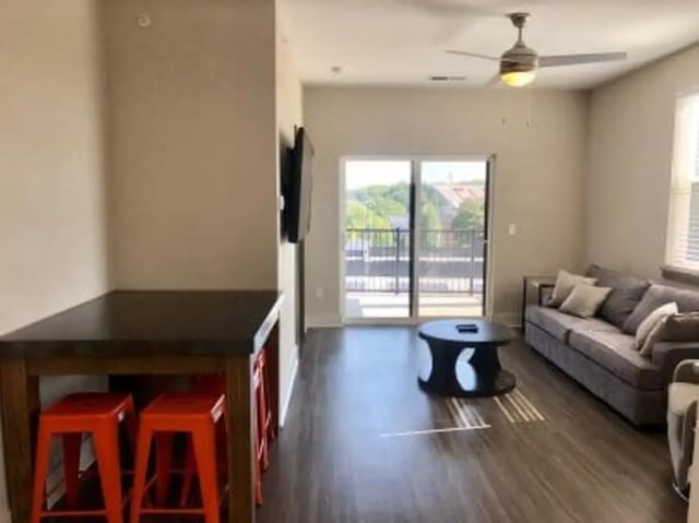 Dining table orange stools couch coffee table living room at Plaza One 89 in Clemson Student Accommodation