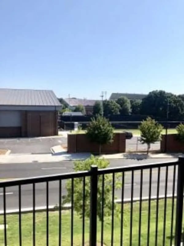 Black railing trees and buildings exterior at Plaza One 89 in Clemson Student Accommodation