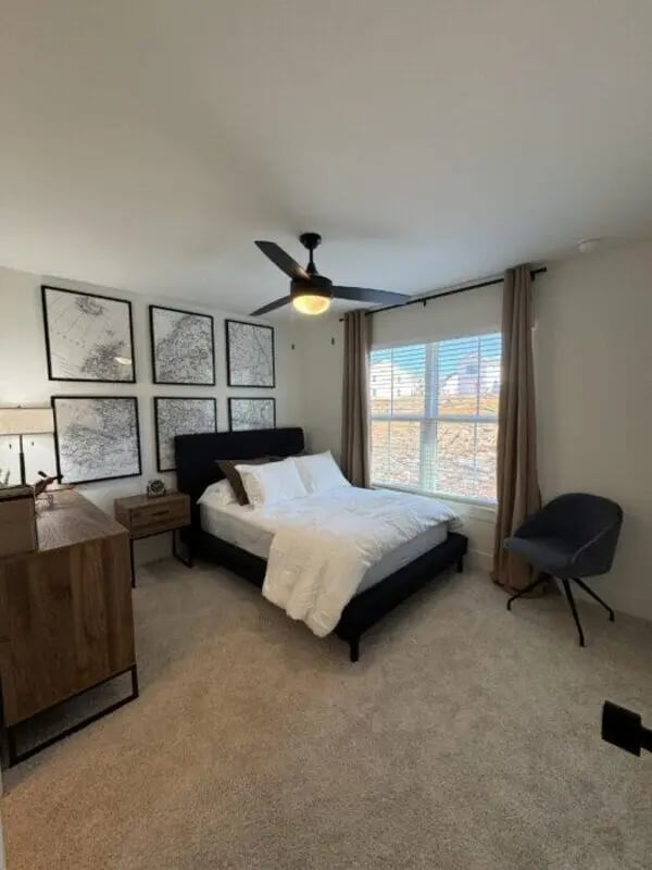 Bed nightstand dresser framed maps ceiling fan bedroom at Maverick Hills in Central Student Accommodation