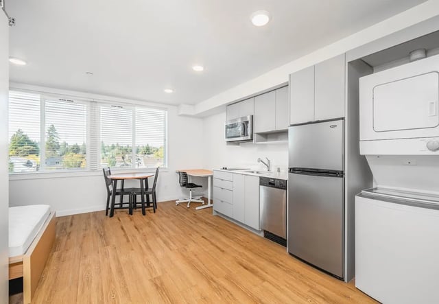 Kitchenette with table chairs fridge washer dryer living area at Thirty One Apartments in Seattle Student Accommodation
