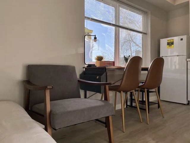 Armchair table chairs and refrigerator studio apartment at Thirty One Apartments in Seattle Student Accommodation