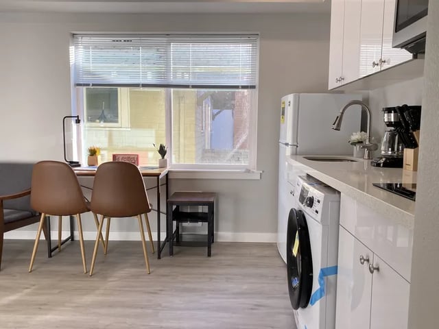 Desk chairs washer dryer and cabinets kitchen area at Thirty One Apartments in Seattle Student Accommodation