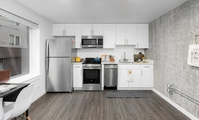 Modern kitchen with stainless steel appliances and white cabinets Kitchen at Montclair Apartments in Seattle Student Accommodation