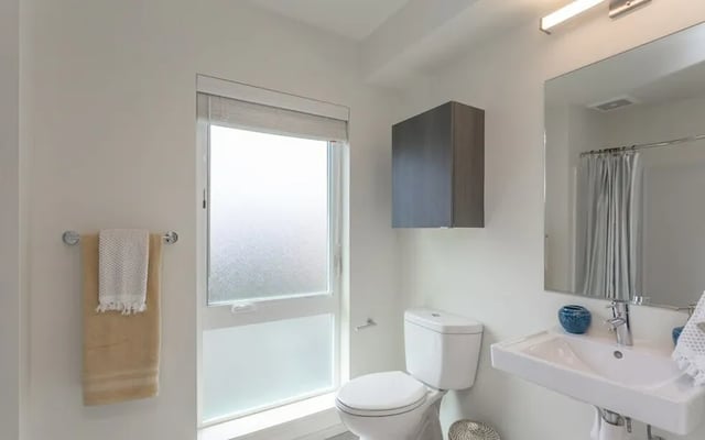 Toilet sink cabinet towels window bathroom at Montclair Apartments in Seattle Student Accommodation