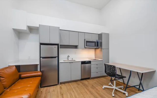 Leather couch desk microwave and refrigerator studio at Montclair Apartments in Seattle Student Accommodation