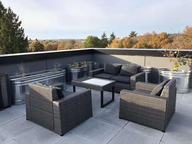 Wicker furniture galvanized planters with plants patio exterior at Montclair Apartments in Seattle Student Accommodation