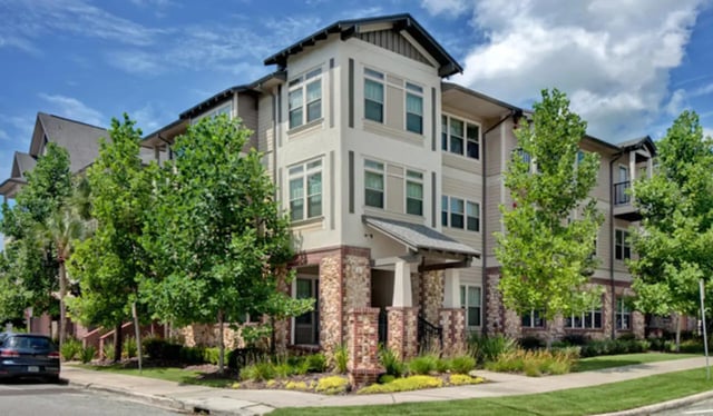 Apartment building with trees and car exterior at Greystone Luxury Apartments in Gainesville Student Accommodation