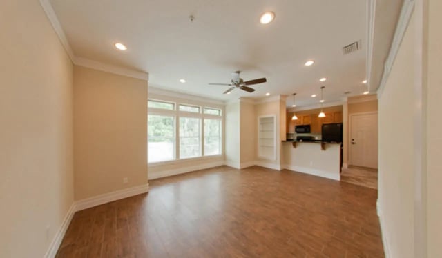 Empty living area with kitchen and large windows. at Greystone Luxury Apartments in Gainesville Student Accommodation