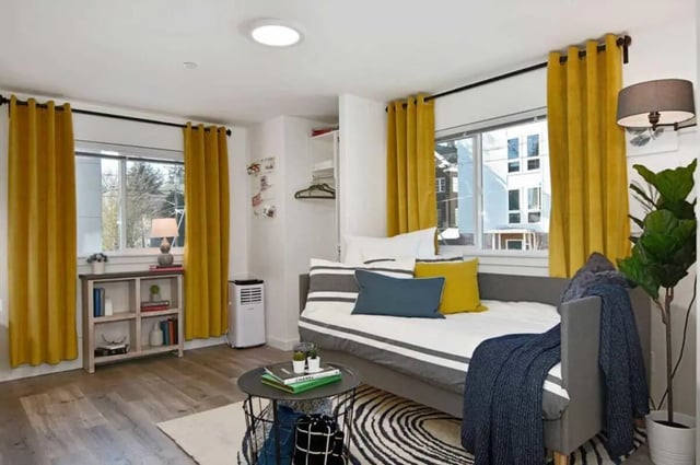 Sofa with pillows air conditioner bookshelf living room at U20 Apartments in Seattle Student Accommodation